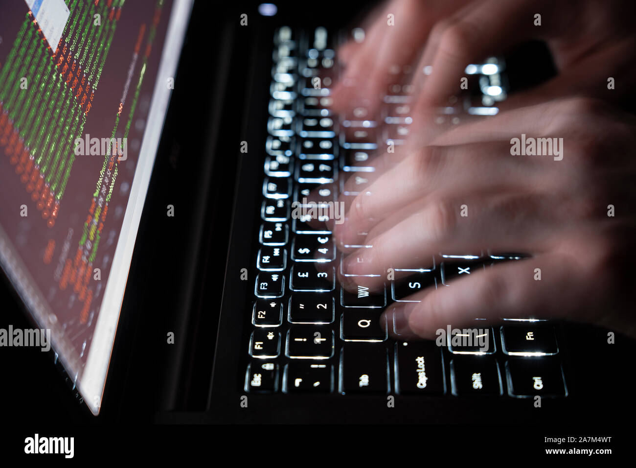 Moving hands typing on a computer keyboard - concept cybersecurity, phishing, hacking, social engineering attack, dark web, viruses and trojans Stock Photo