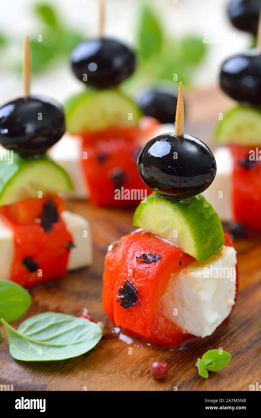 Greek appetizers Feta cheese skewers with grilled and pickled red peppers, snack cucumbers and