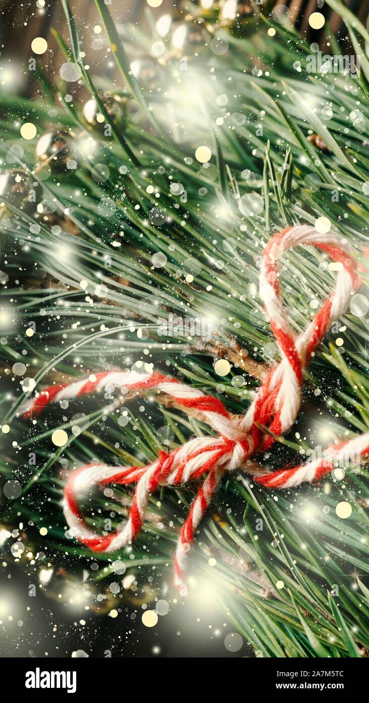 Christmas tree needles with decorations and falling fluffy snowflakes