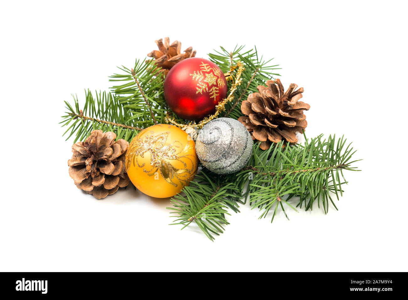 Pine cones with spruce tree branch and Christmas decoration bauble balls on a white background. Stock Photo