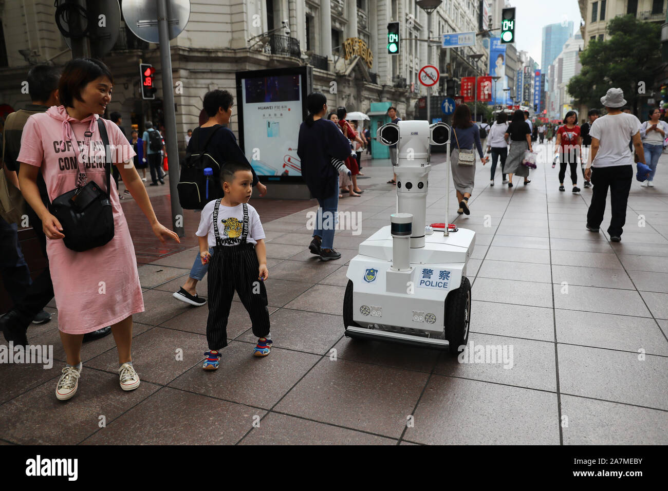 People look at the robot patrolman on Nanjing East Road in Shanghai, China, 4 September 2019. Stock Photo