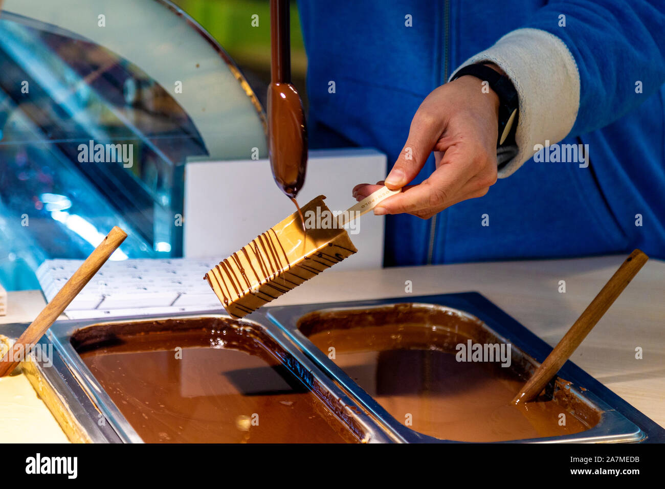 Ice lolly being dipped in chocolate at Loco Polo, San Sebastian, Spain Stock Photo