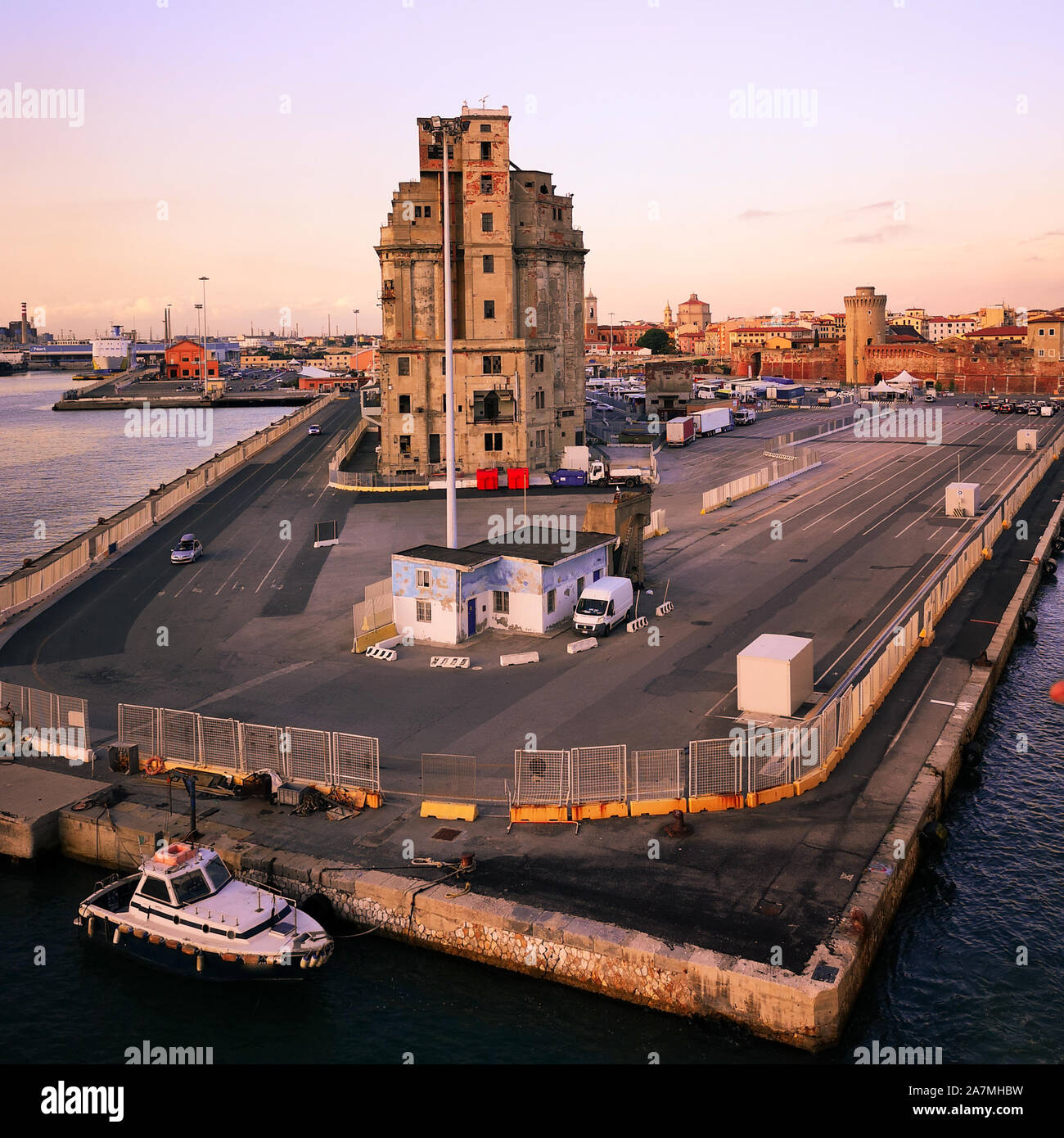 View of a quay of the port of Livorno at sunset. Abandoned building. Industrial archeology. Stock Photo