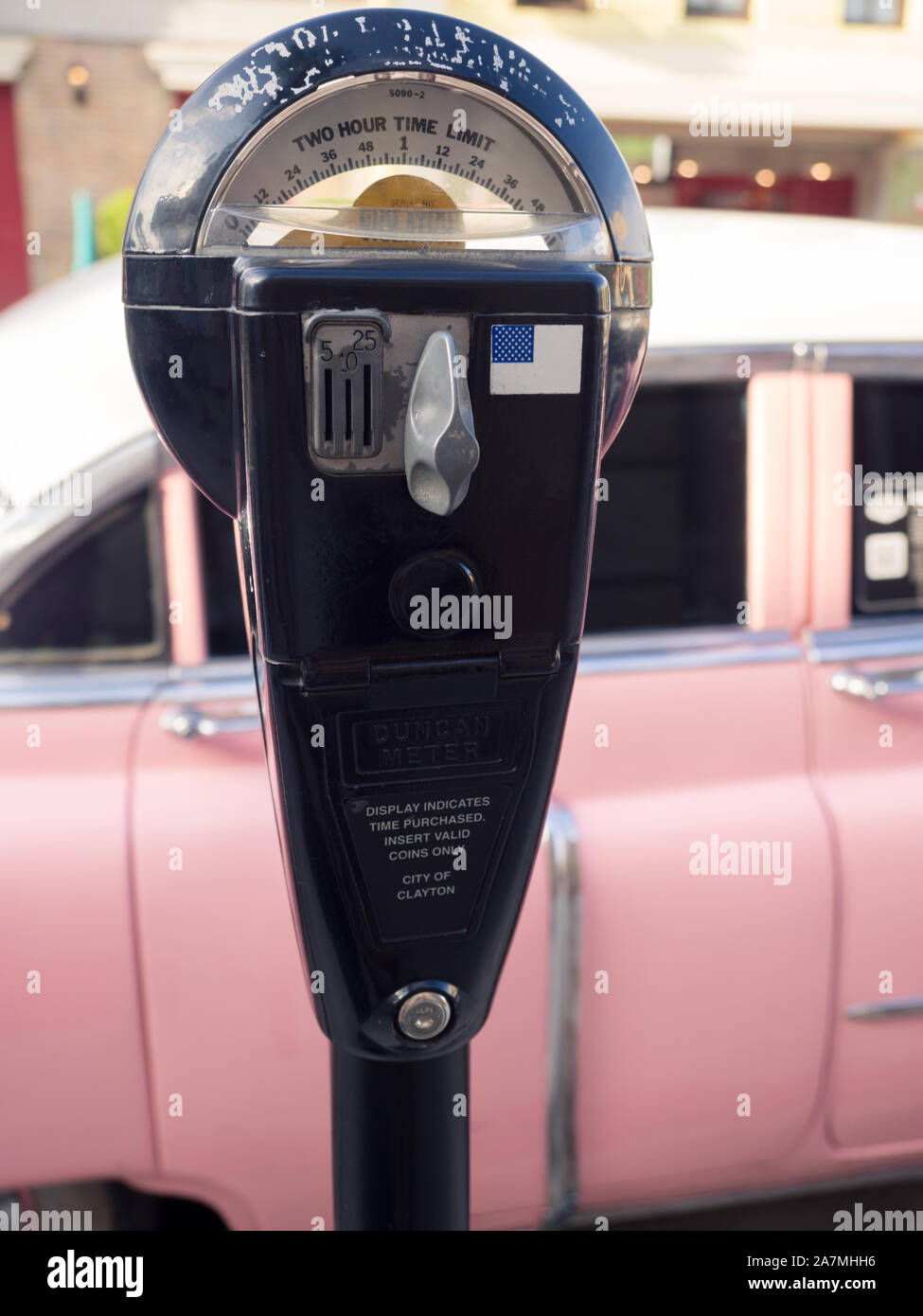Old parking meter and a vintage car in the background. Stock Photo
