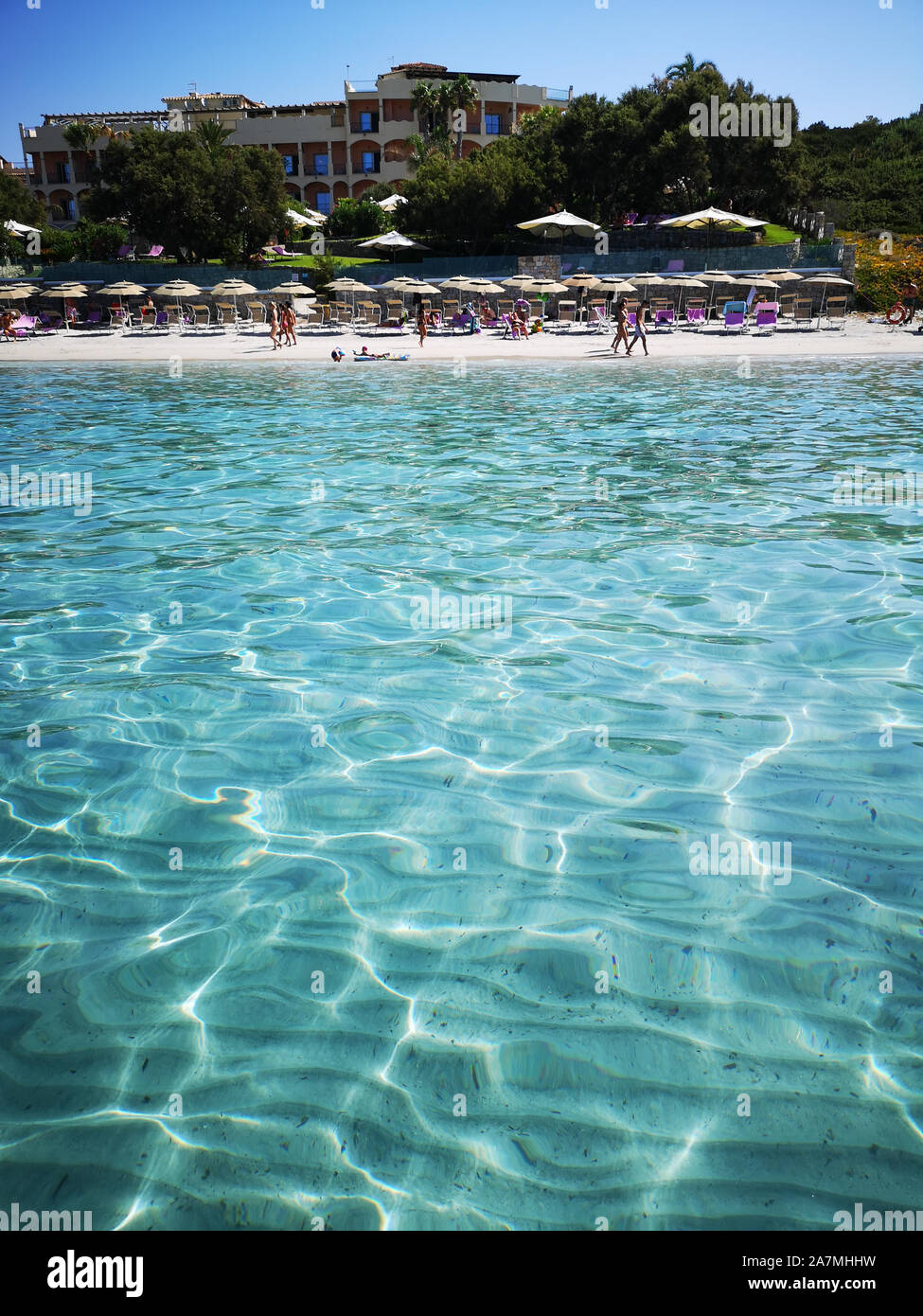 Blue and transparent water and the light sand of a beach in Sardinia. Stock Photo