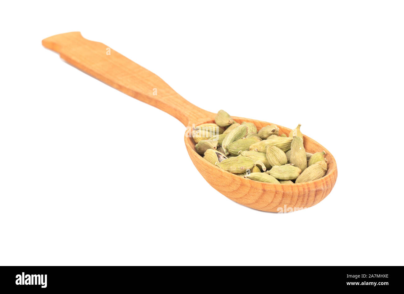 Dry cardamom in a large wooden spoon on a white background Stock Photo
