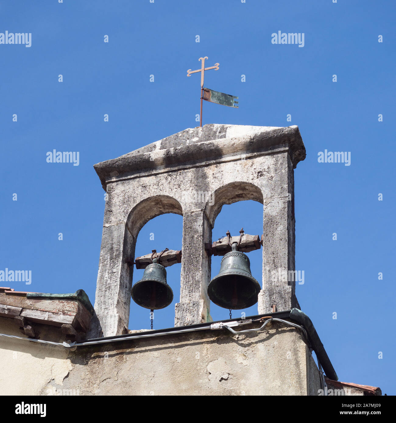 Detail of the bell tower of an ancient small Catholic church. Stock Photo