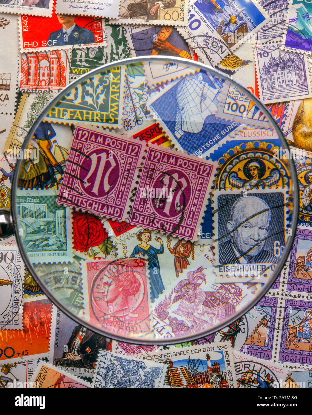 German and international postage stamps with magnify glass Stock Photo