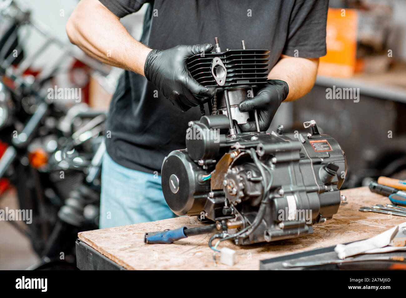 Workman disassembling motorcycle engine during a repairment at the working table of the workshop close up with no face Stock Photo Alamy