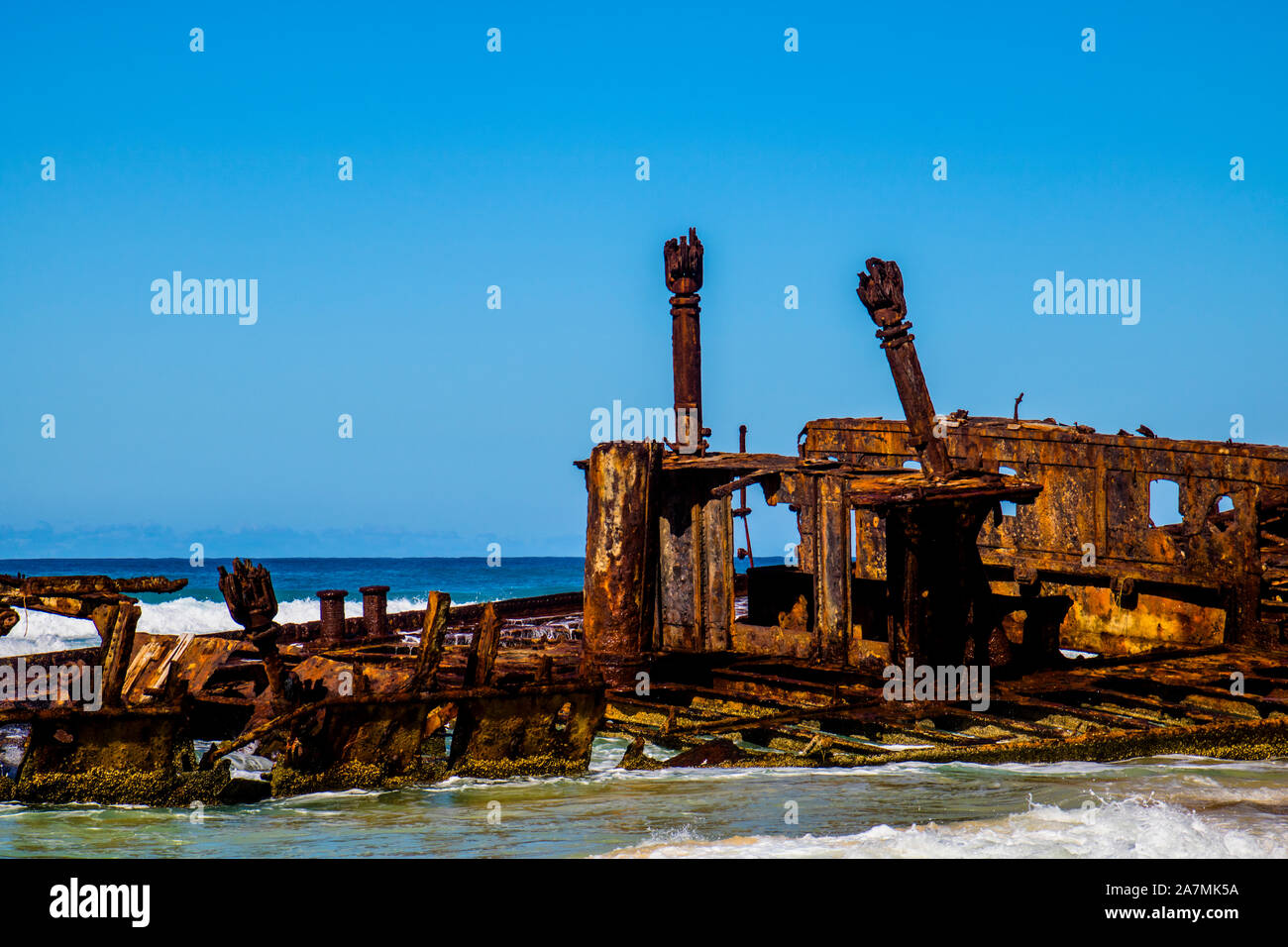Photograph of the shipwreck of the SS Maheno on Fraser Island with a cloudless sky in the background. Fraser Island is located off Queensland in easte Stock Photo
