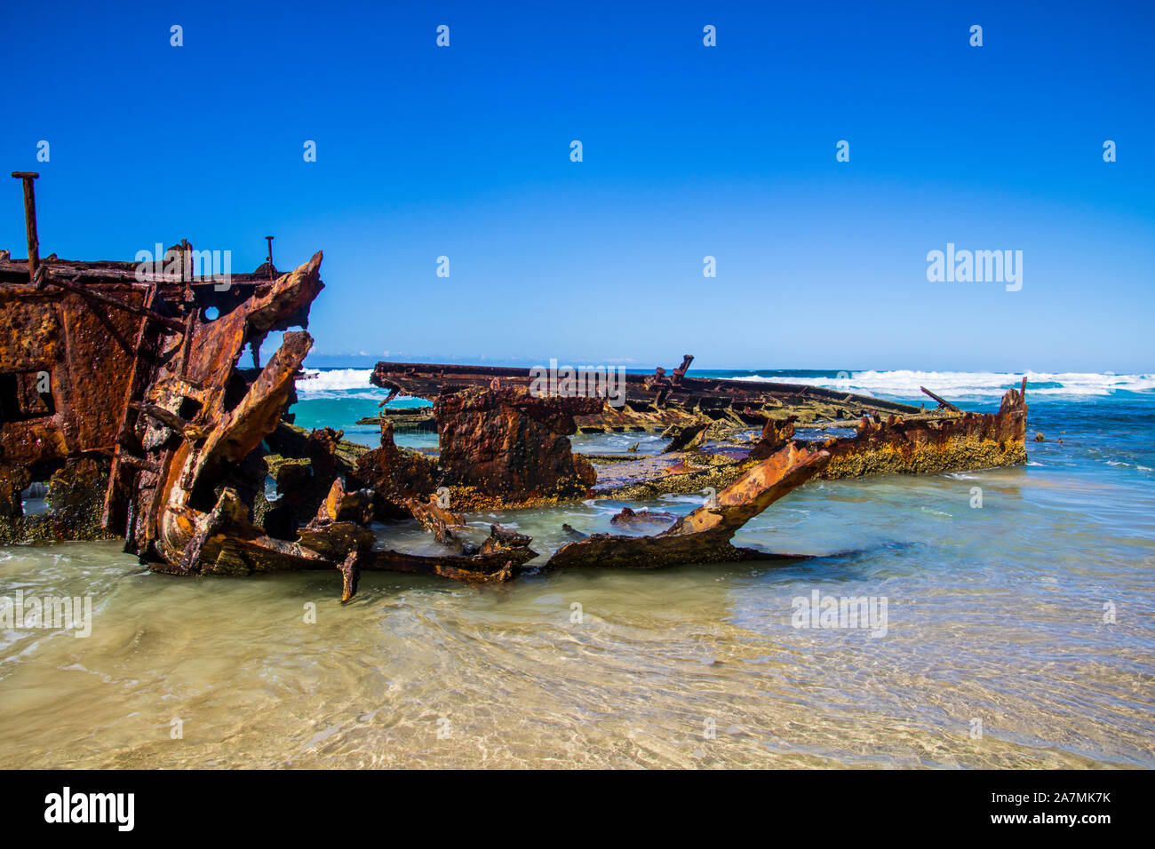 Photograph of the shipwreck of the SS Maheno on Fraser Island with a cloudless sky in the background. Fraser Island is located off Queensland in easte Stock Photo