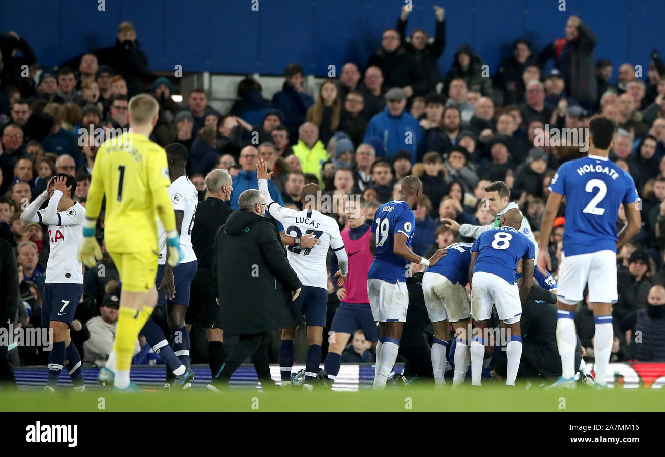Everton check on the condition of team-mate Andre Gomes as referee Martin Atkinson consoles Tottenham Hotspur's Son Heung-min (left) after a challenge during the Premier League match at Goodison Park, Liverpool. Stock Photo