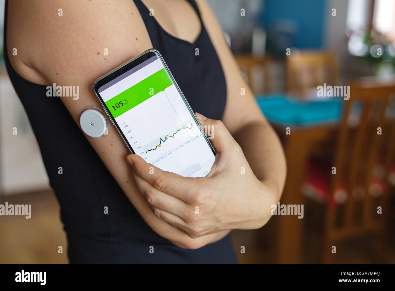 Woman checking glucose level with a modern technology remote sensor and