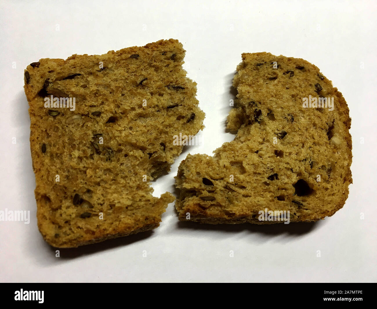 The photo shows slice toast, homemade bread with caraway isolated closeup in white background. Bread photos consisting of cut brown bakery products, r Stock Photo