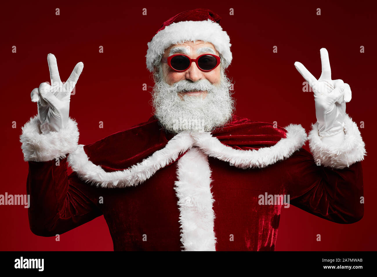 Waist up portrait of funky Santa wearing sunglasses and smiling at camera ready to enjoy Christmas party Stock Photo
