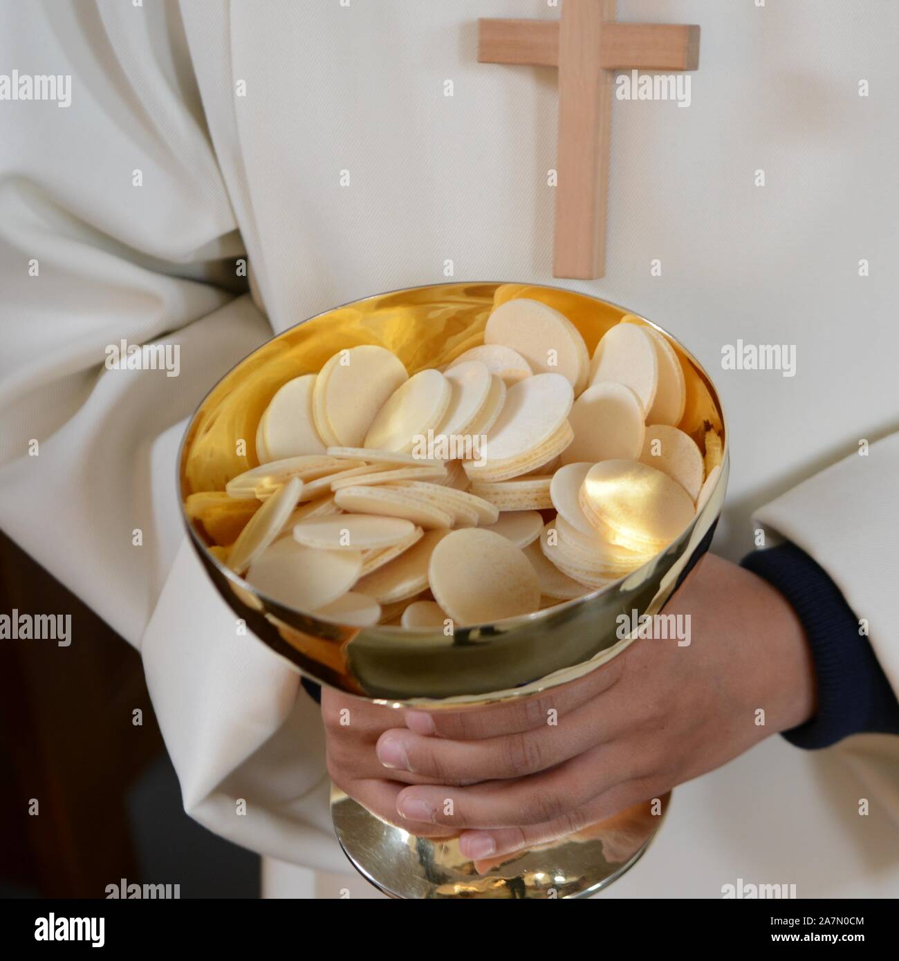 Altar Boy, Acolyte hold chalice with waver Stock Photo