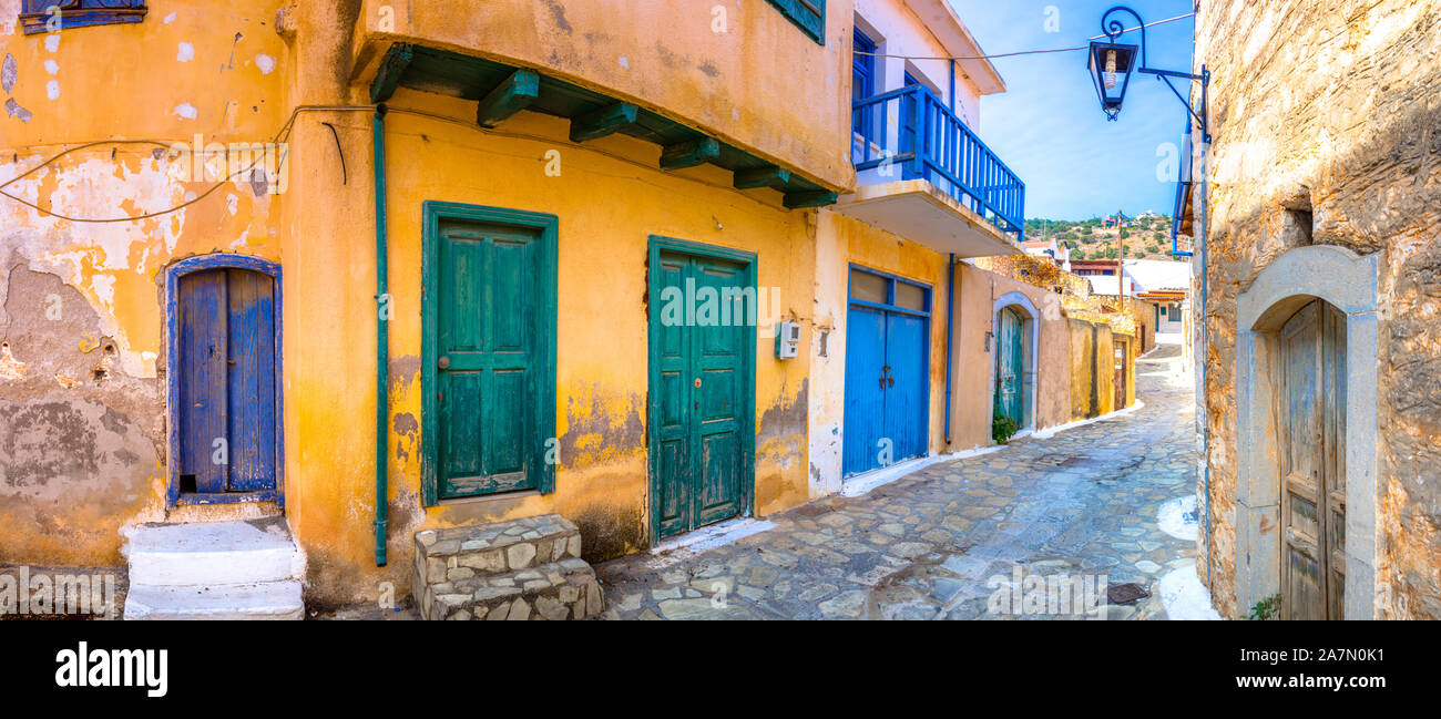 Narrow street with colorful stone houses in the old village of Pano Elounda, Crete, Greece. Stock Photo