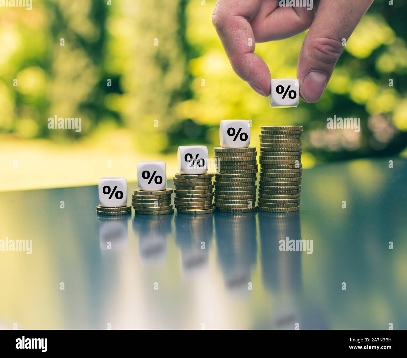 Percentage signs on increasing high stacks of coins. Stock Photo