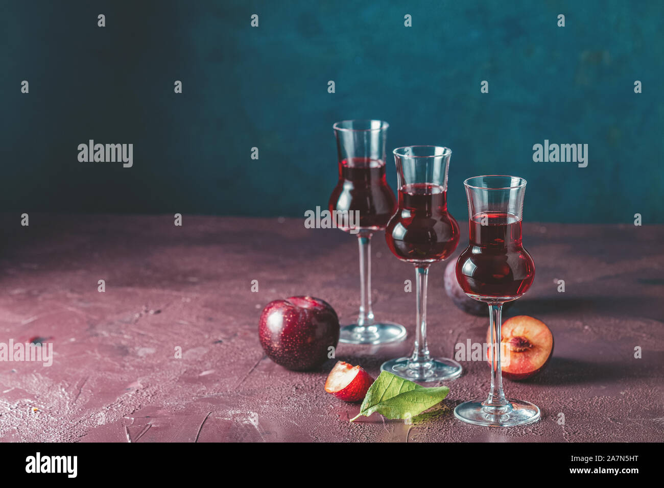 Plums strong alcoholic drink in grappas wineglass with dew. Hard liquor, slivovica, plum brandy