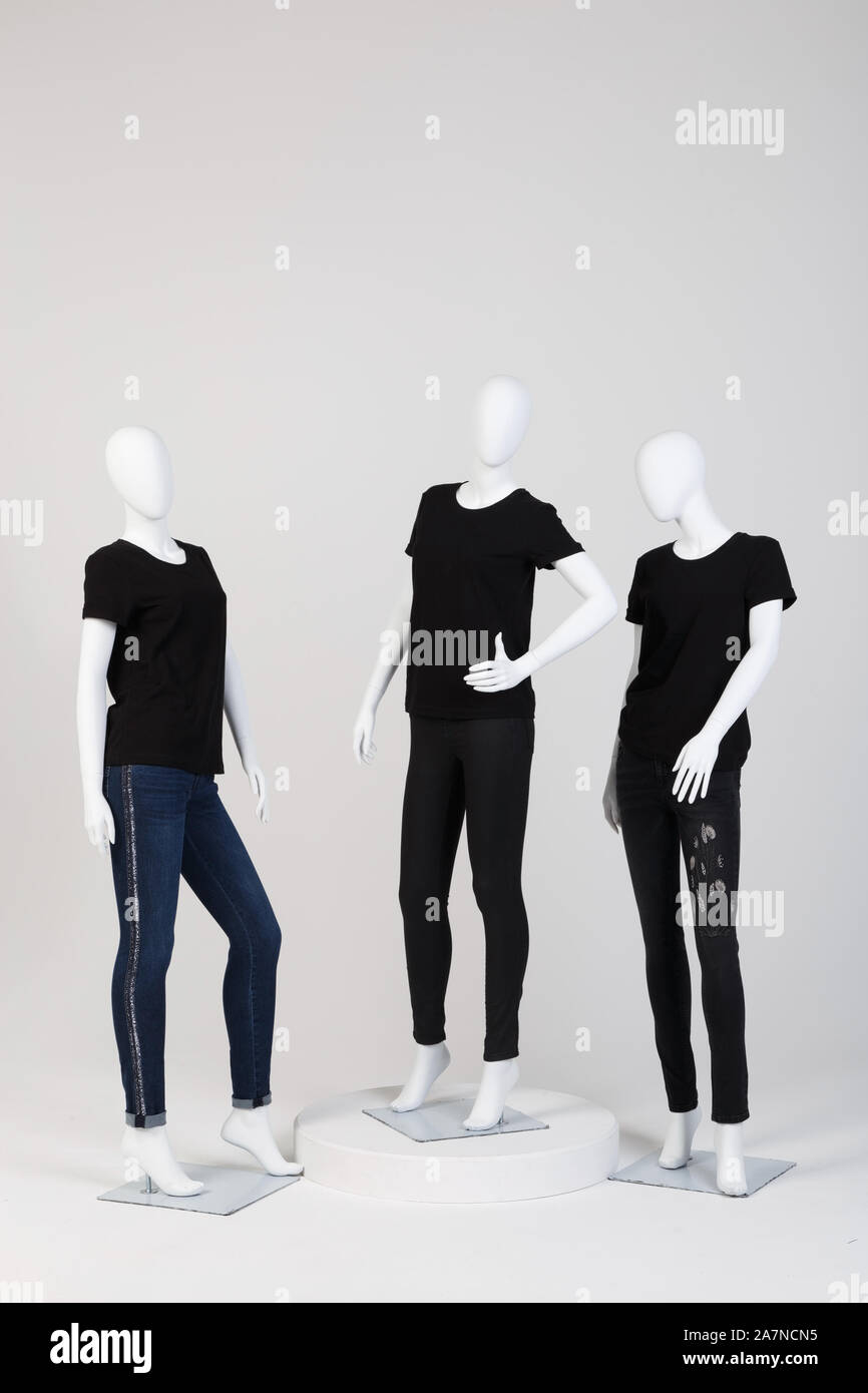 Three female mannequins dressed in fashionable black clothes over white  background. Stock Photo