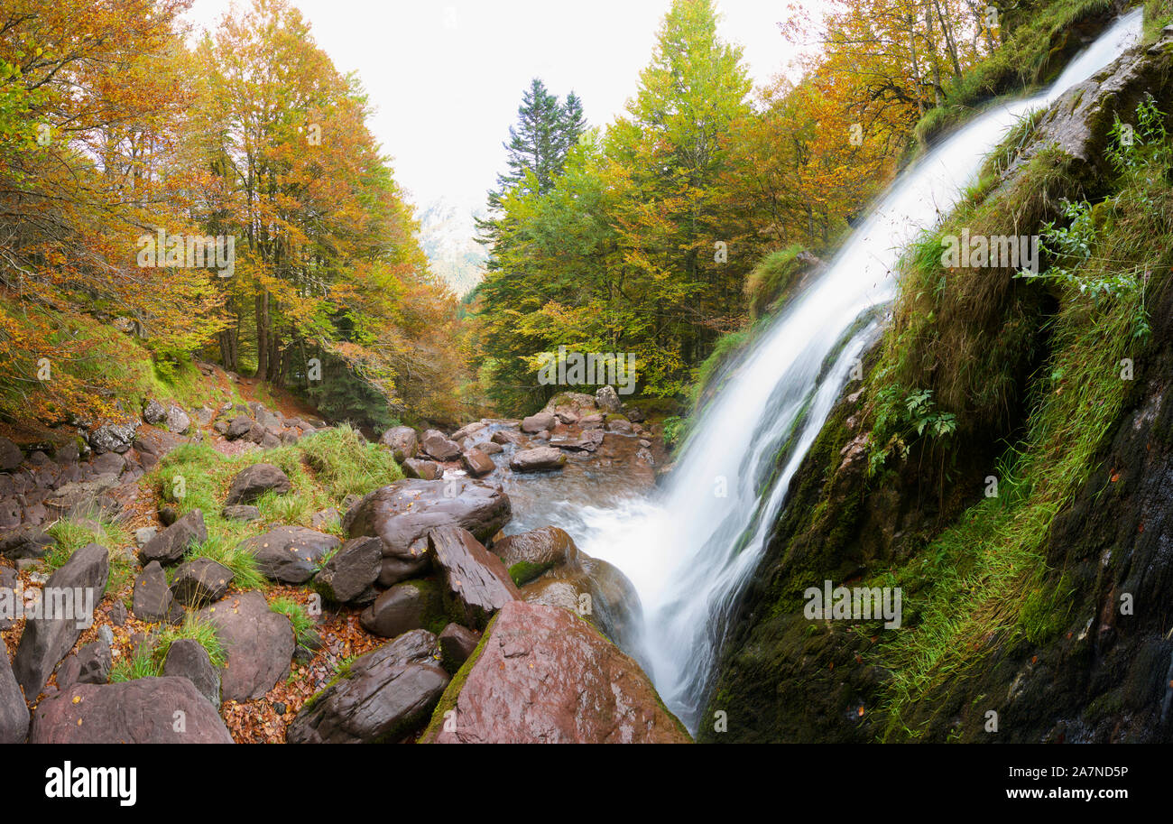 Waterfall in a autumnal forest in the Aspe Valley. Stock Photo