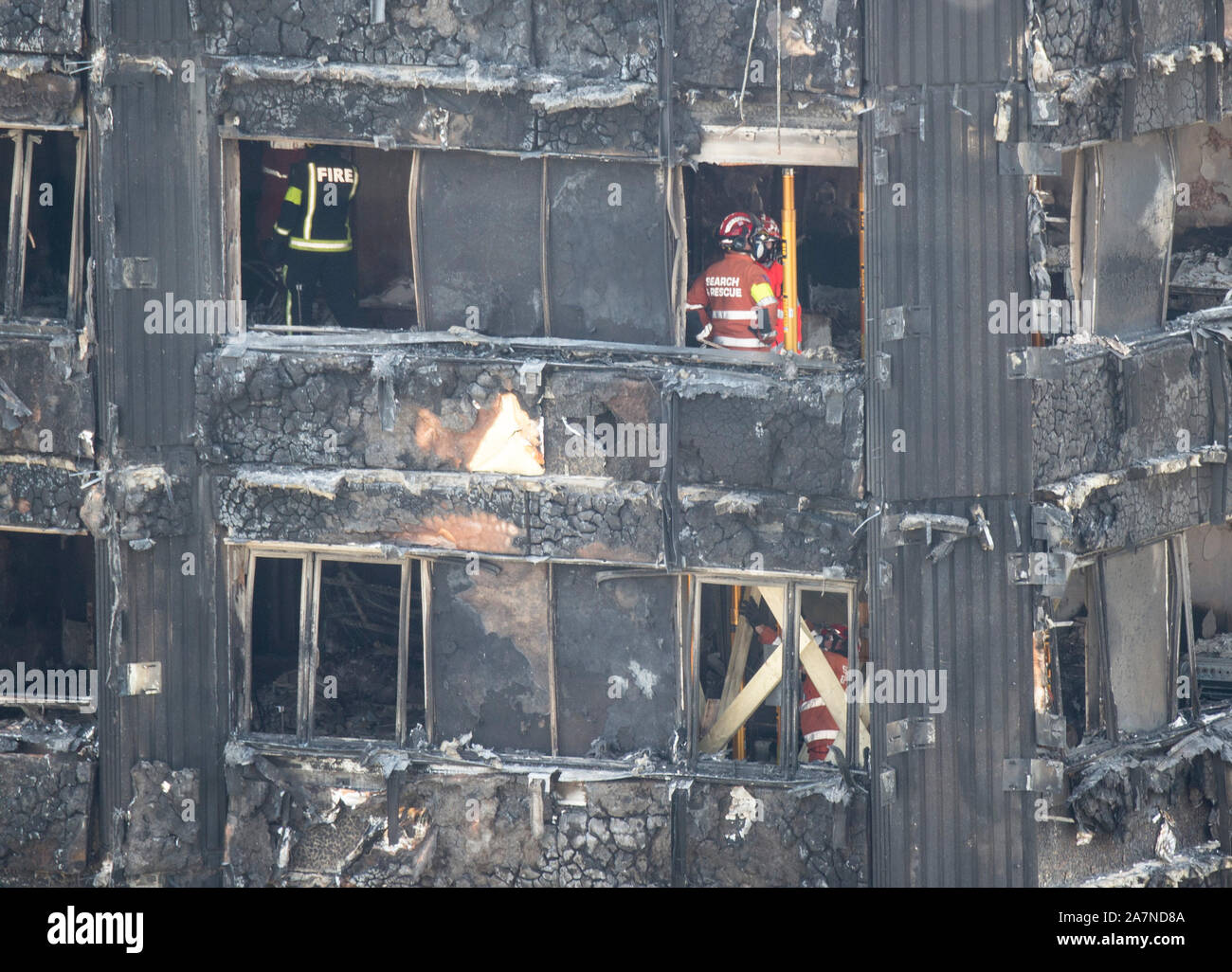 Firefighters and members of the Urban Search and Rescue team break for a moments silence before they continue to search for victims in the remains of Grenfell Tower fire disaster in North Kensington, West London. The fire was the deadliest domestic fire since the second world war. The fire broke out in the 24 storey block of flats just before 1:00am on the 14th June 2017 causing 72 deaths and injuring more than 70 people. Stock Photo