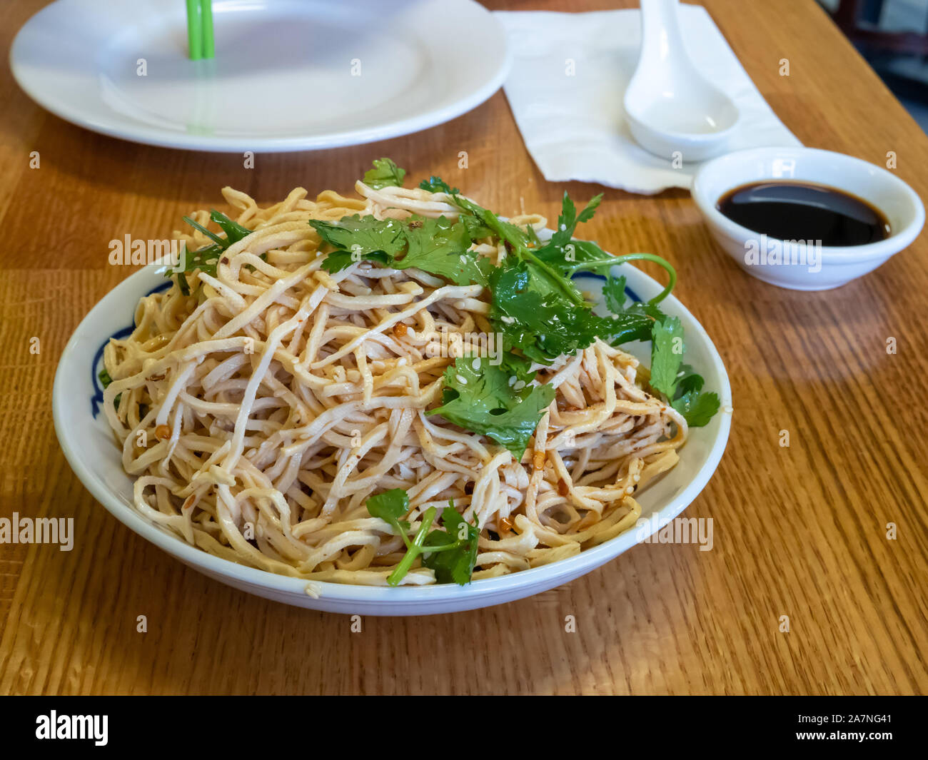 Bowl of fresh cilantro noodles on table of Chinese food restaurant Stock Photo