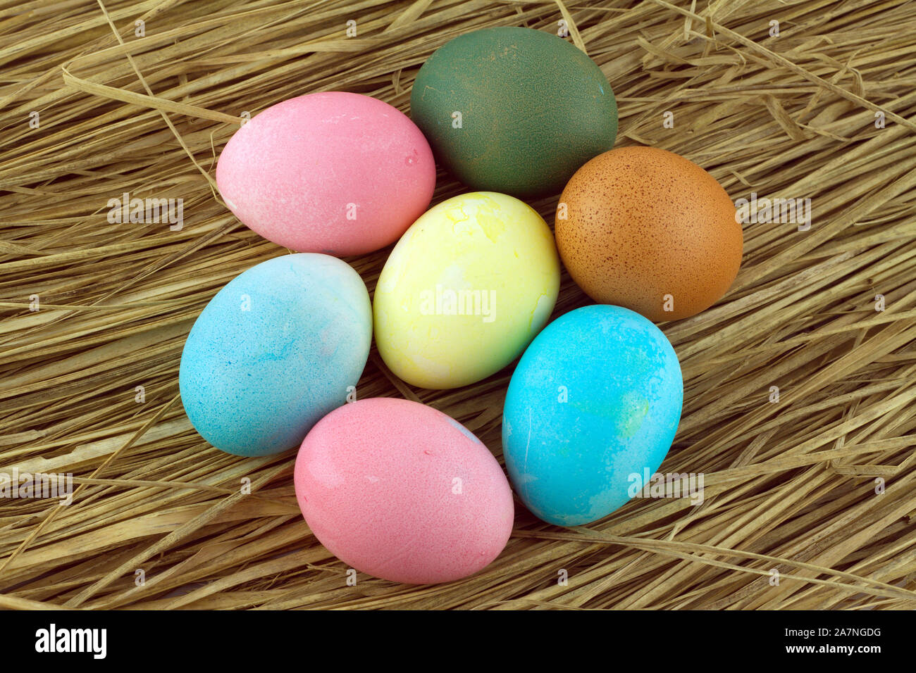 Colorful Easter eggs on straw background closeup Stock Photo