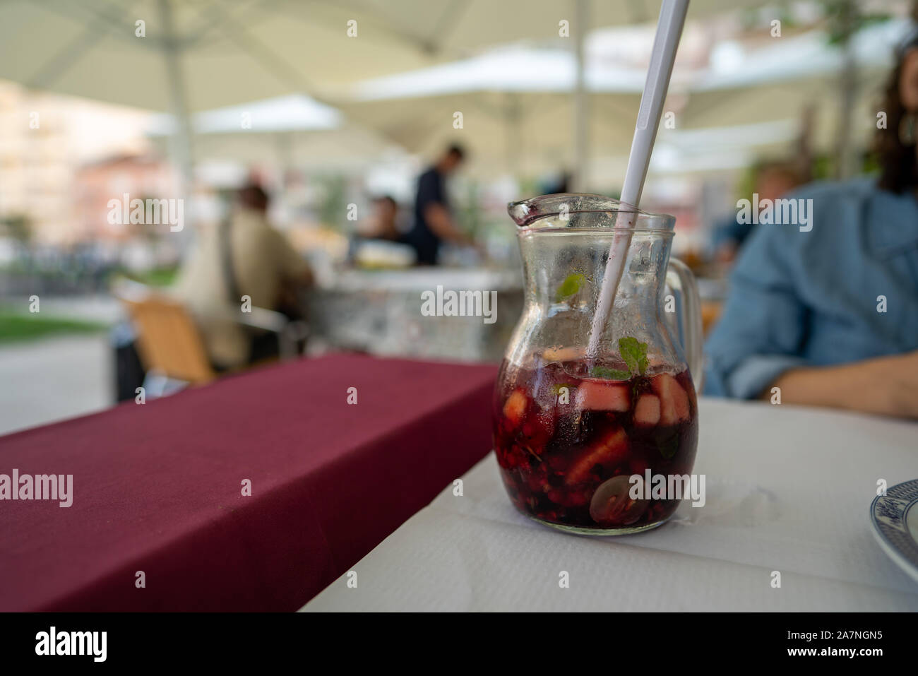 https://c8.alamy.com/comp/2A7NGN5/pitcher-of-red-sangria-on-table-at-restaurant-being-consumed-by-woman-2A7NGN5.jpg