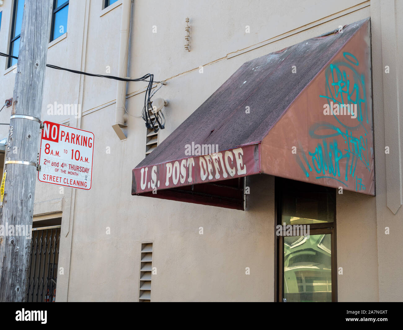 Beat up US post office awning covered in graffiti and some filth Stock Photo