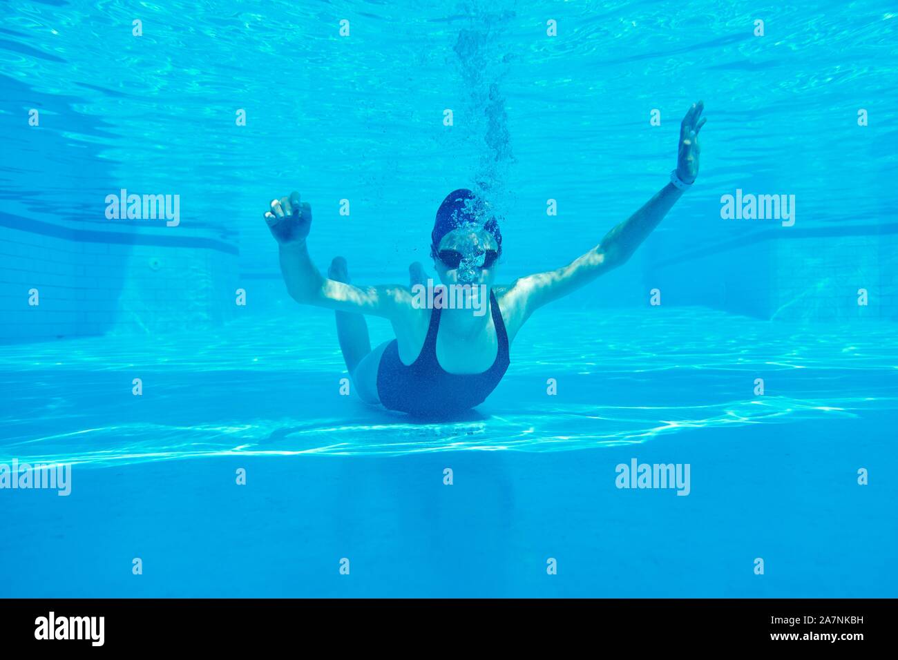 Young girl swimmer in swimsuit with goggles and swimming cap underwater in pool Stock Photo Alamy