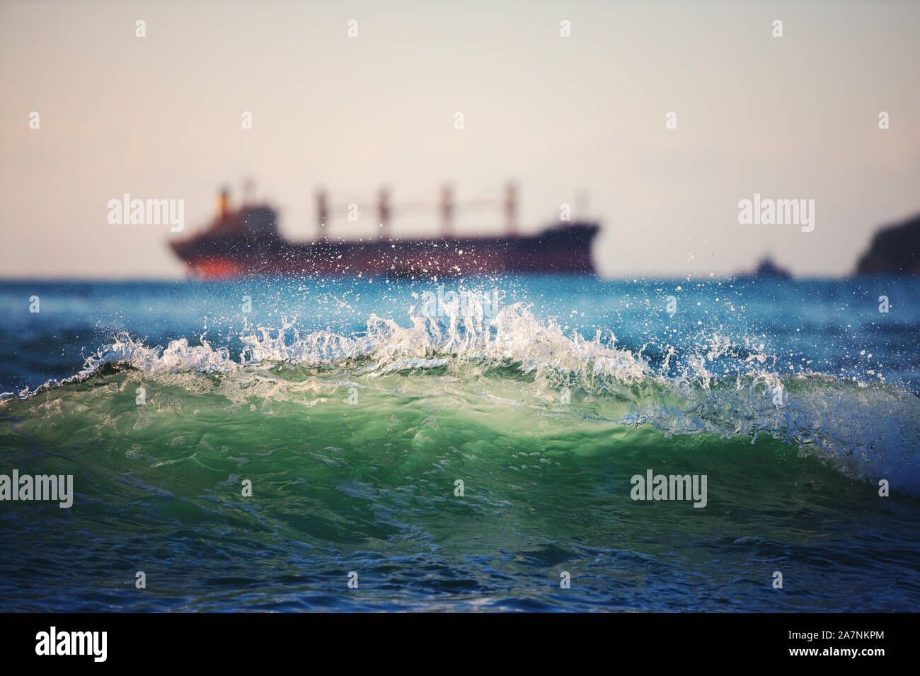 Sailing cargo ship and waves at sunrise. Transportation. Logistics. Shipping Stock Photo