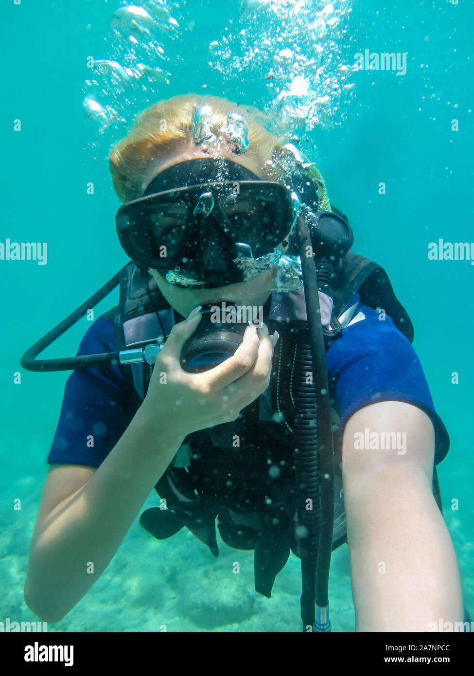 Young caucasian  woman dressed in diving equipment swimming underwater in ionian sea .Greece , Corfu scuba diving in vacation   Women   making selfie Stock Photo