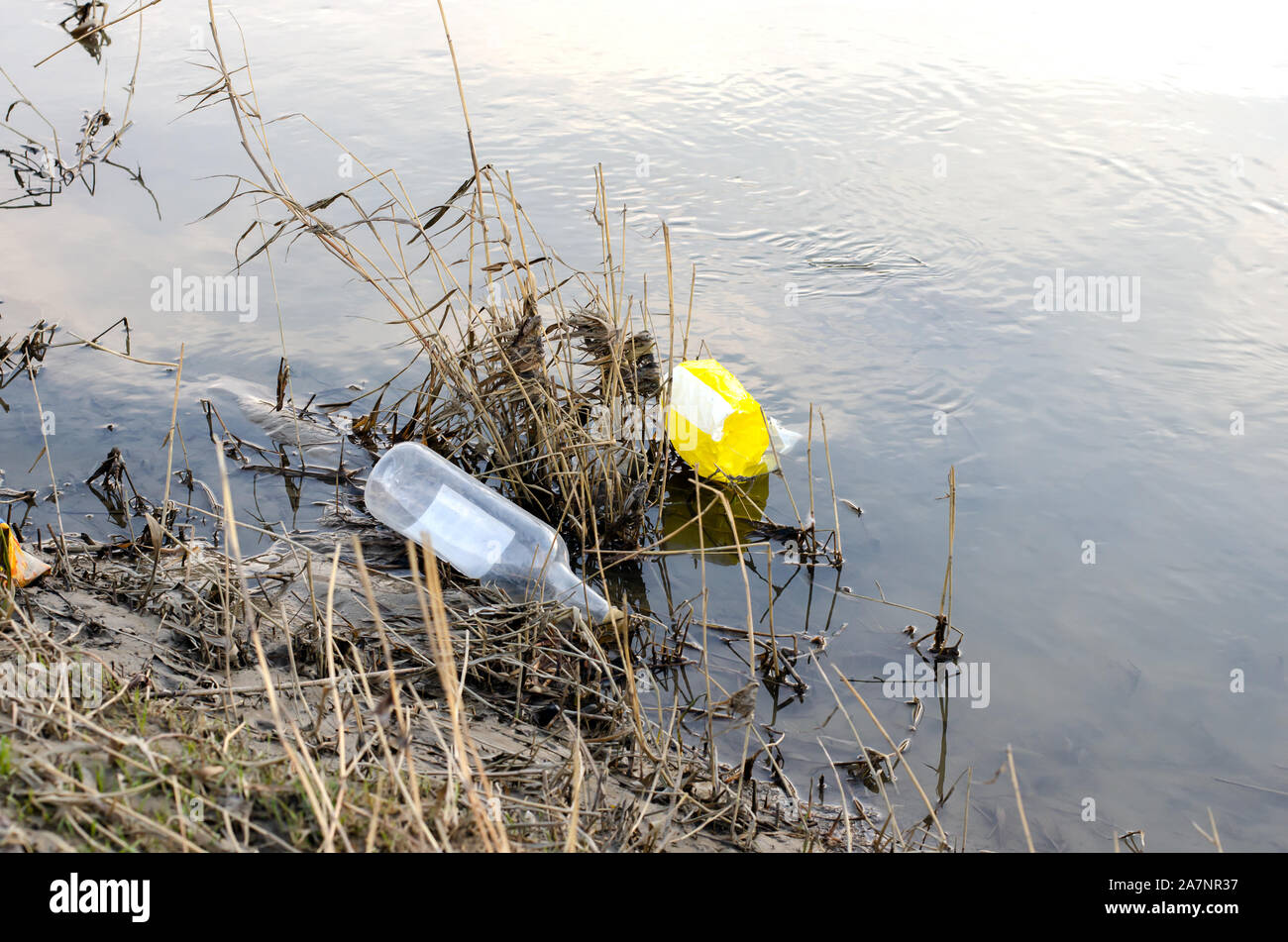 Abandoned plastic bag and bottle garbage at the lakeshore Stock Photo
