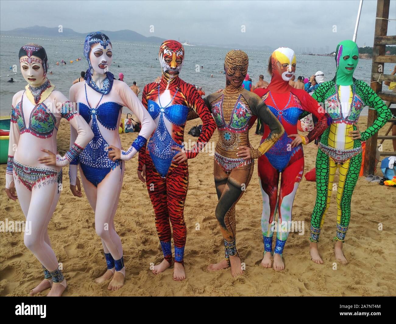 Models display new creations of facekini collection featuring Chinese cultural elements on the beach during a press conference in Qingdao city, east C Stock Photo