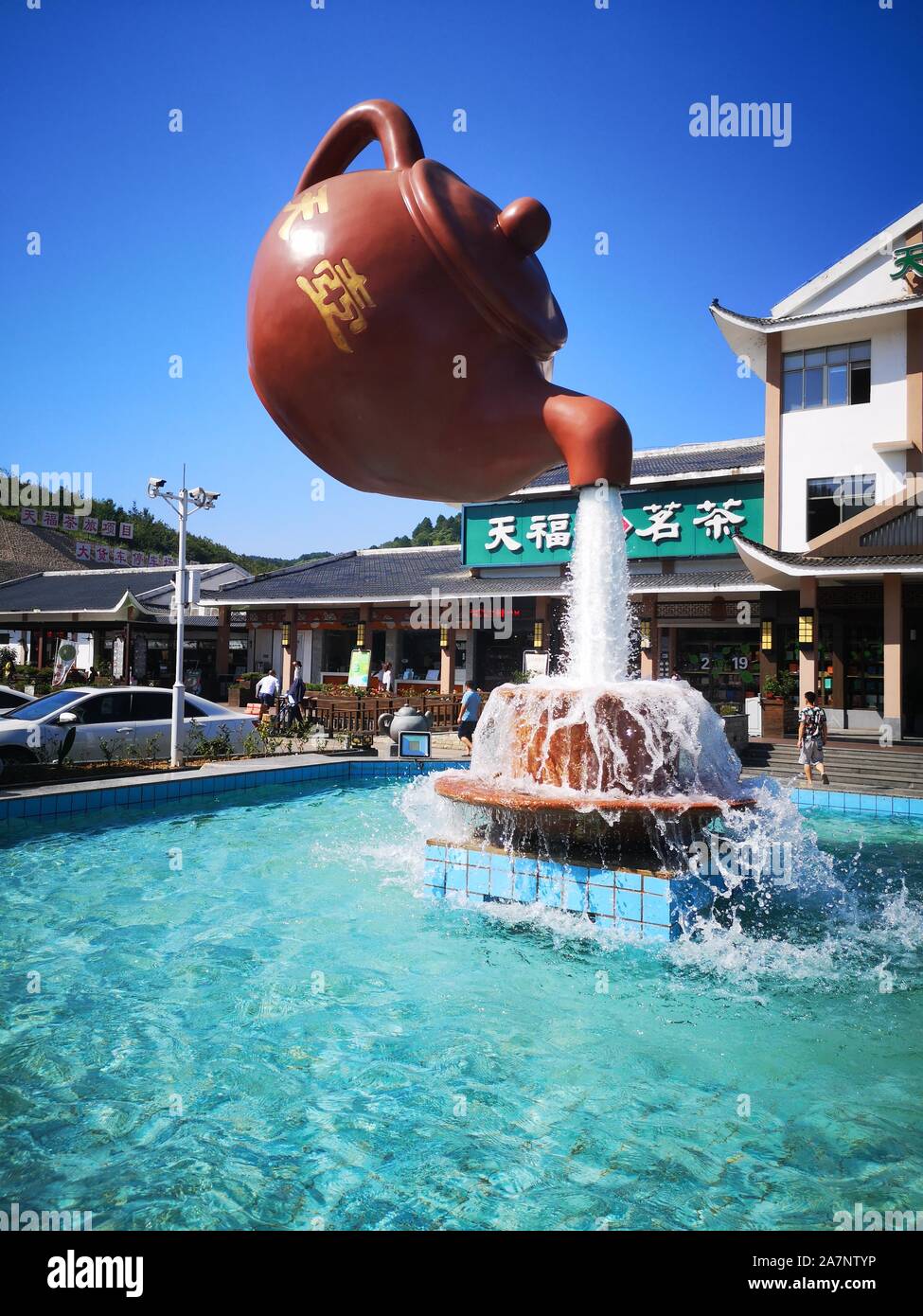 A giant floating teapot and teacup water fountain is displayed at an