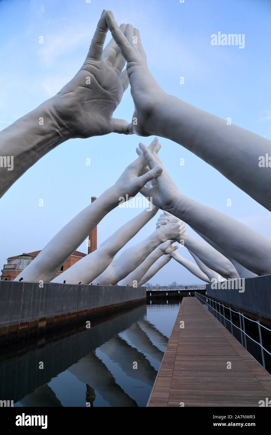 Art Biennale Venice 2019. Giant joined hands sculpture 'Building Bridges' by Lorenzo Quinn. Love. Exhibition at Arsenale, Castello, Venice. Stock Photo