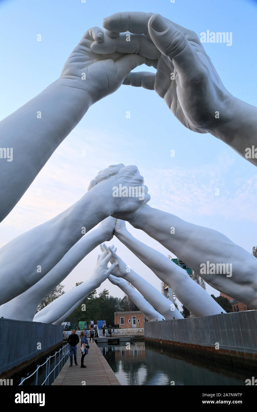 Art Biennale Venice 2019. Giant joined hands sculpture 'Building Bridges' by Lorenzo Quinn. Help and wisdom. Exhibition at Arsenale, Castello, Venice. Stock Photo