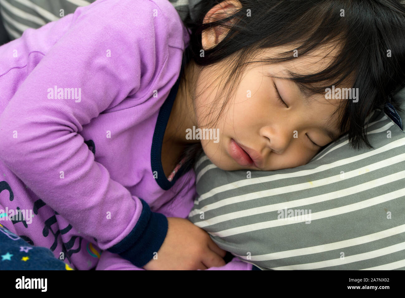 Little Asian child taking nap on couch Stock Photo