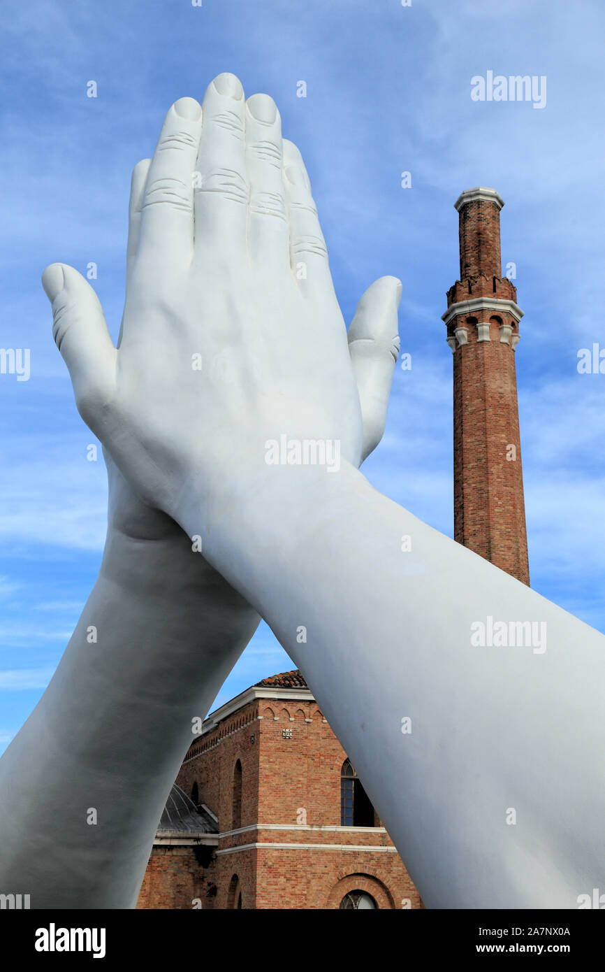 Art Biennale Venice 2019. Giant joined hands sculpture 'Building Bridges' by Lorenzo Quinn. Faith. Exhibition at Arsenale, Castello, Venice. Stock Photo