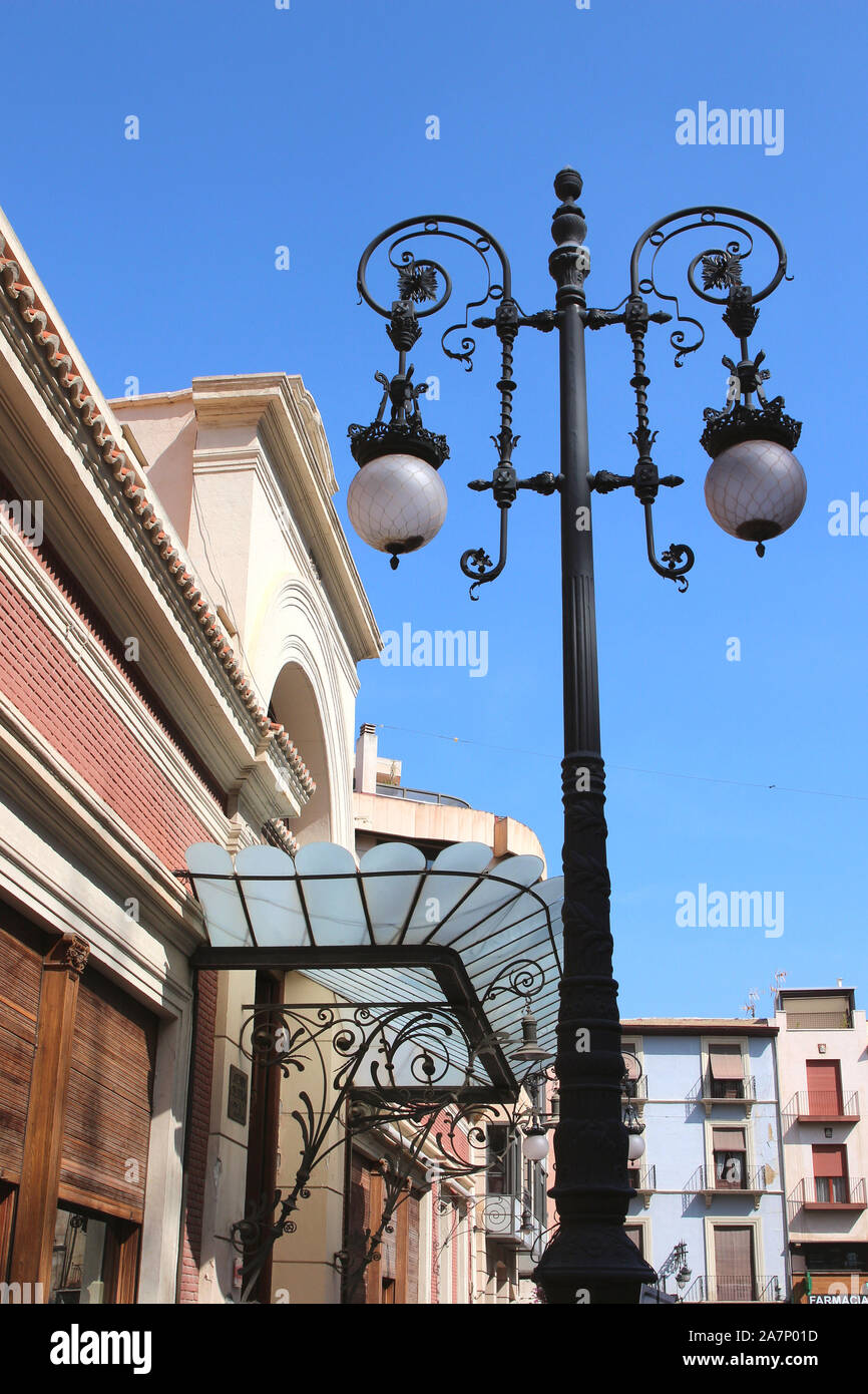 One of the beautiful street lights in Orihuela, Alicante Province, Spain. This one is standing near the iron and glass canopy of the casino entrance. Stock Photo