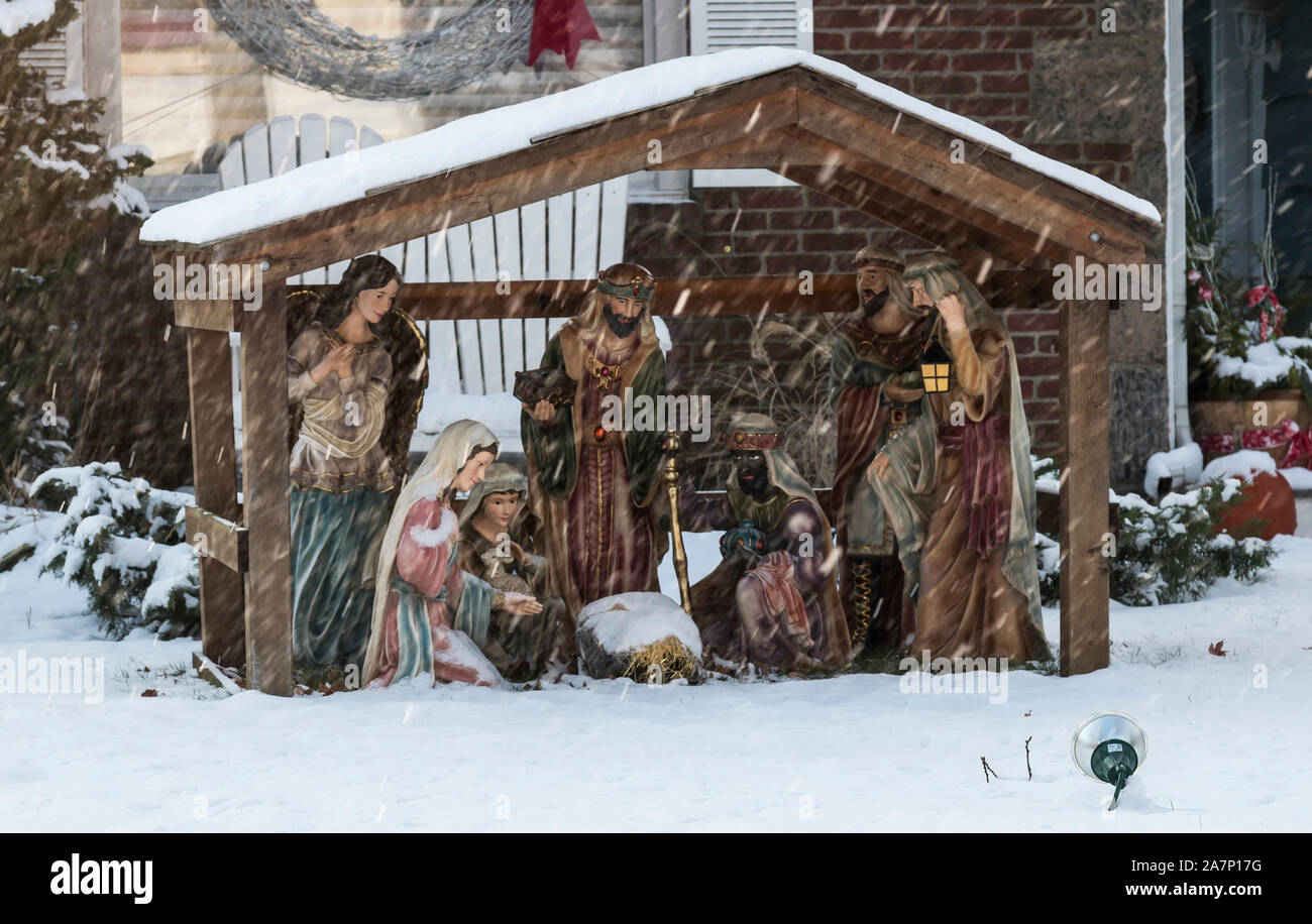 A nativity scene set up ona lawn to celebrate Christmas is getting covered in snow as a early December storm arrives. Stock Photo