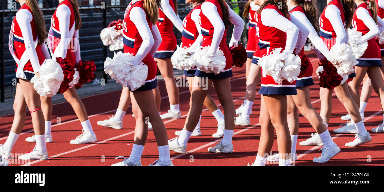A group of high school cheerleaders are cheering from the track during