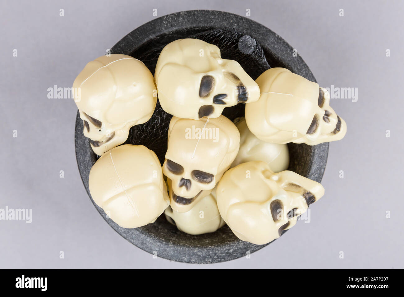 Bone white plastic skull figures in a bowl Stock Photo Alamy