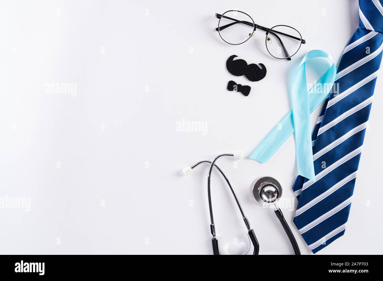 Blue ribbon with tie and stethoscope on white background representing an annual event during the month of November to raise awareness of men's health Stock Photo
