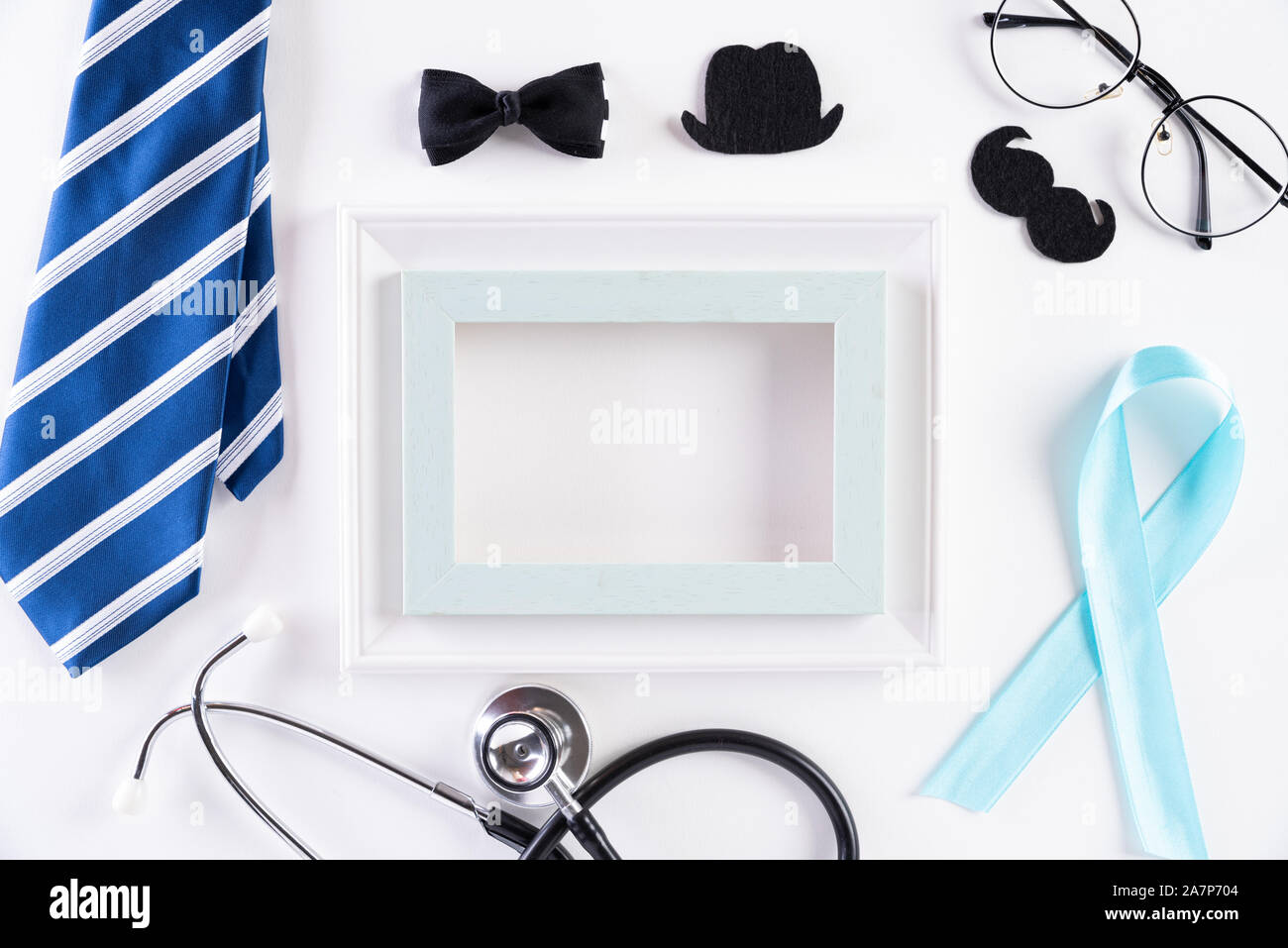 Blue ribbon with tie and stethoscope on white background representing an annual event during the month of November to raise awareness of men's health Stock Photo