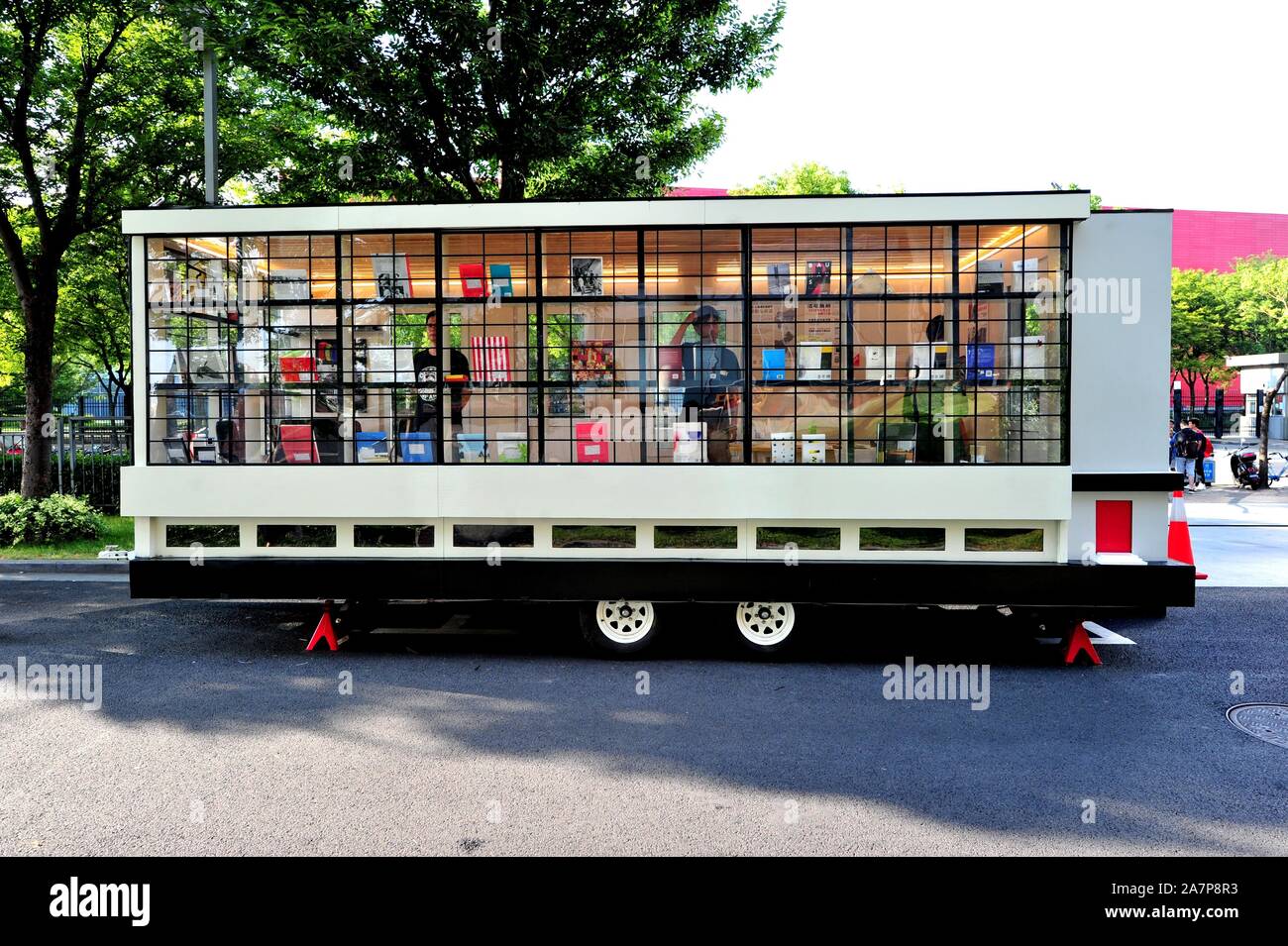 Pedestrians walk past the Bauhaus caravan Wohnmaschine during the Pudong Reading Festival at the Shanghai Pudong Library in Shanghai, China, 7 August Stock Photo