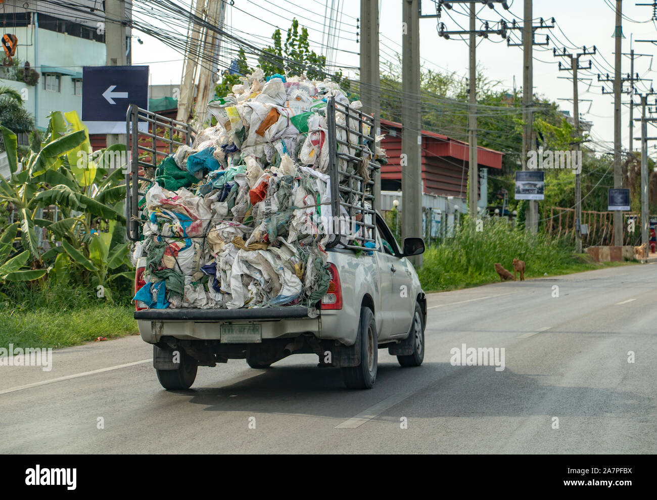 A fully loaded pickup carries a pile of old used empty bags, Bangkok
