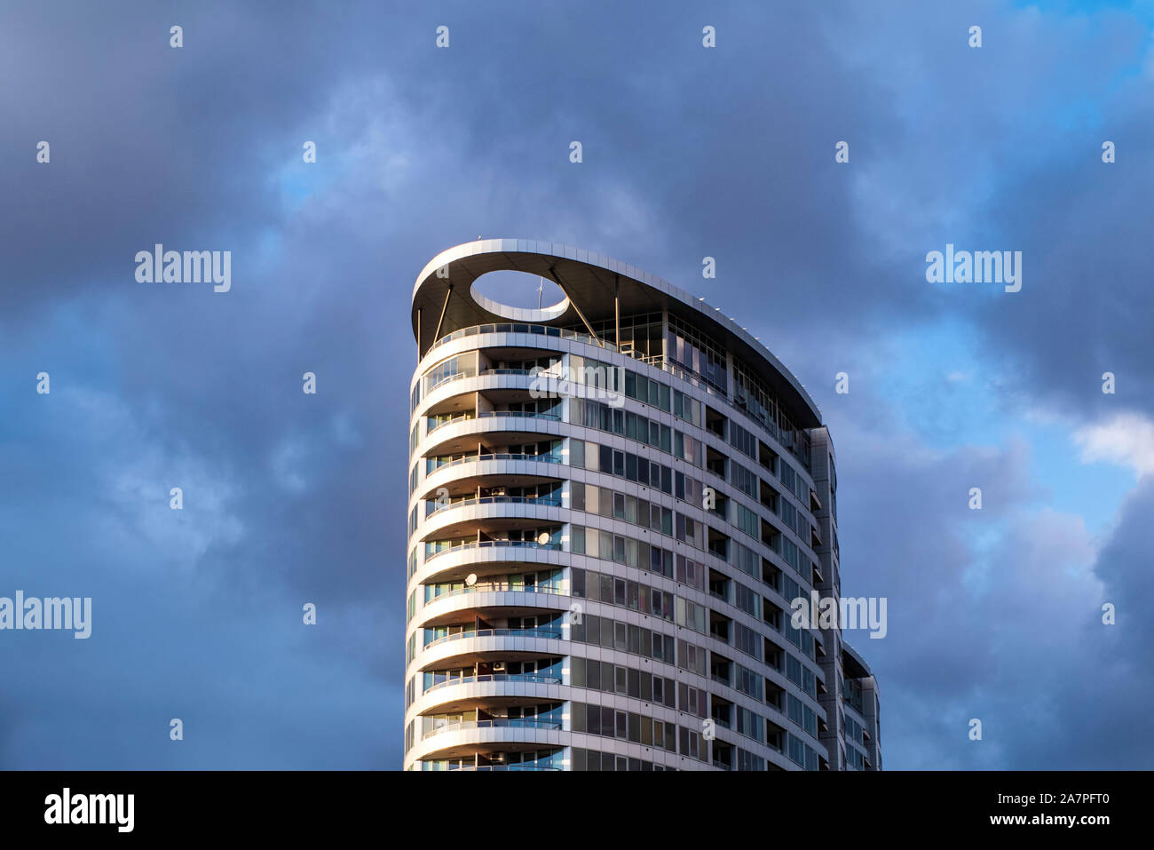 High-rise building on a cloudy sky background. Gray clouds. Building a business center.Cloudy sky . Stock Photo