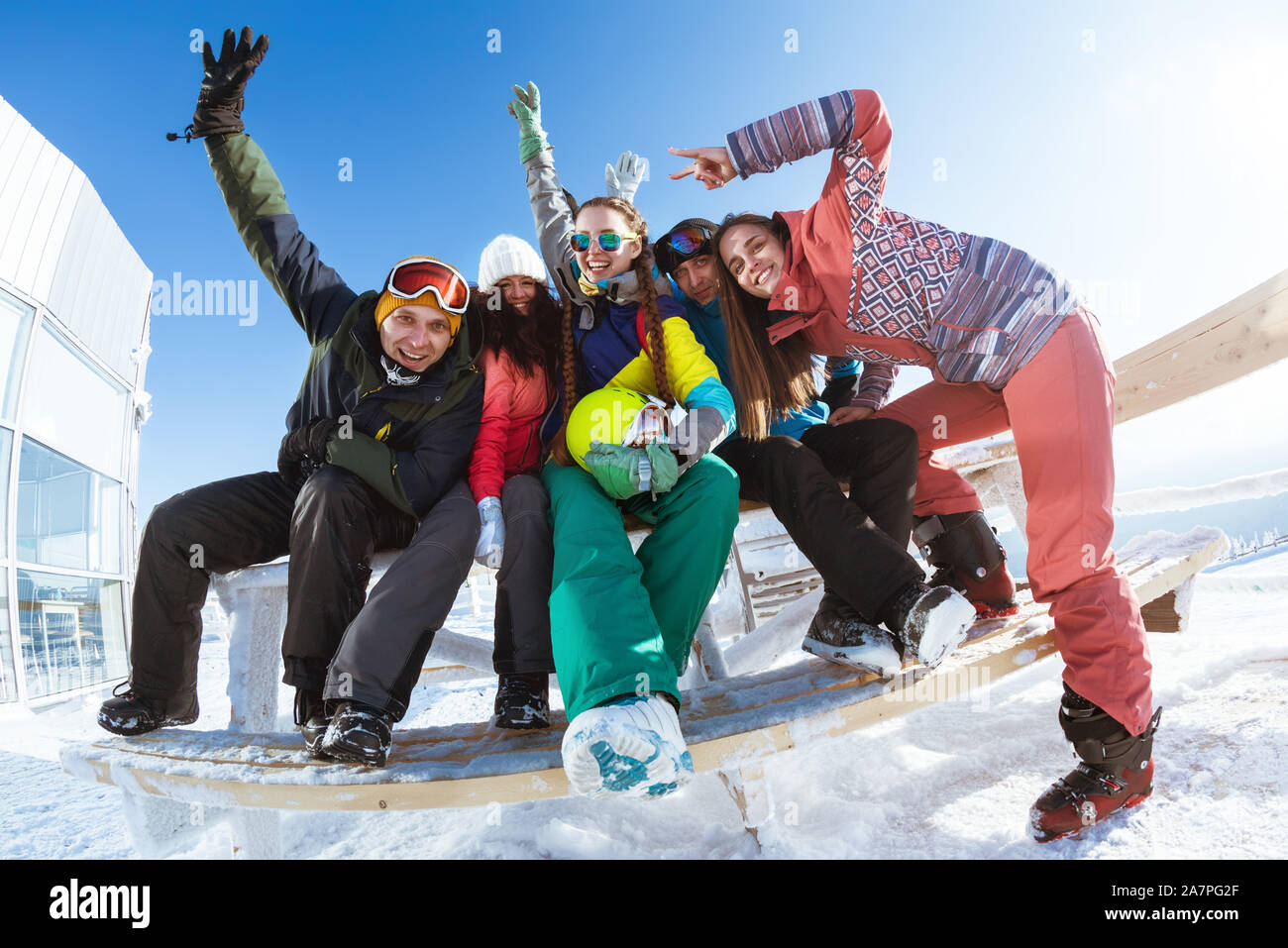 Five happy friends skiers and snowboarders are having fun and posing together at ski resort Stock Photo